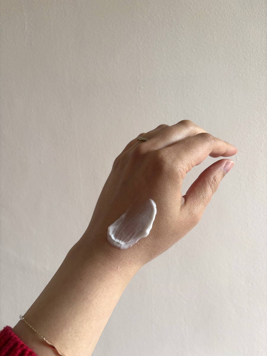 Mica Ricketts showing swatch and texture of Murad Essential-C Overnight Barrier Repair Cream on hand