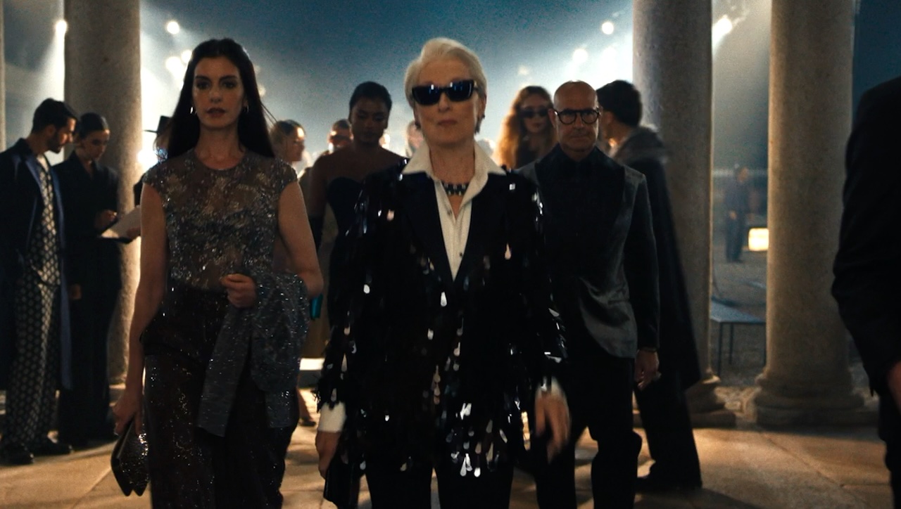 Andy and Miranda walking at night, with Nigel behind them in The Devil Wears Prada 2