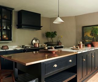 peninsula kitchen with dark blue cabinetry and marble counters