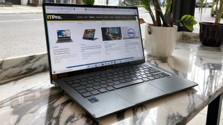 The Acer Swift 5 placed on a desk in a cafe, seen from a 45-degree angle