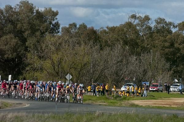 The peloton passes school children in Bunnaloo around a minute behind two breakaway riders.