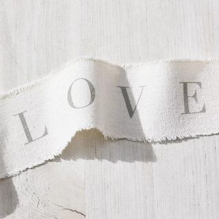 White ribbon with the words 'Love' on it