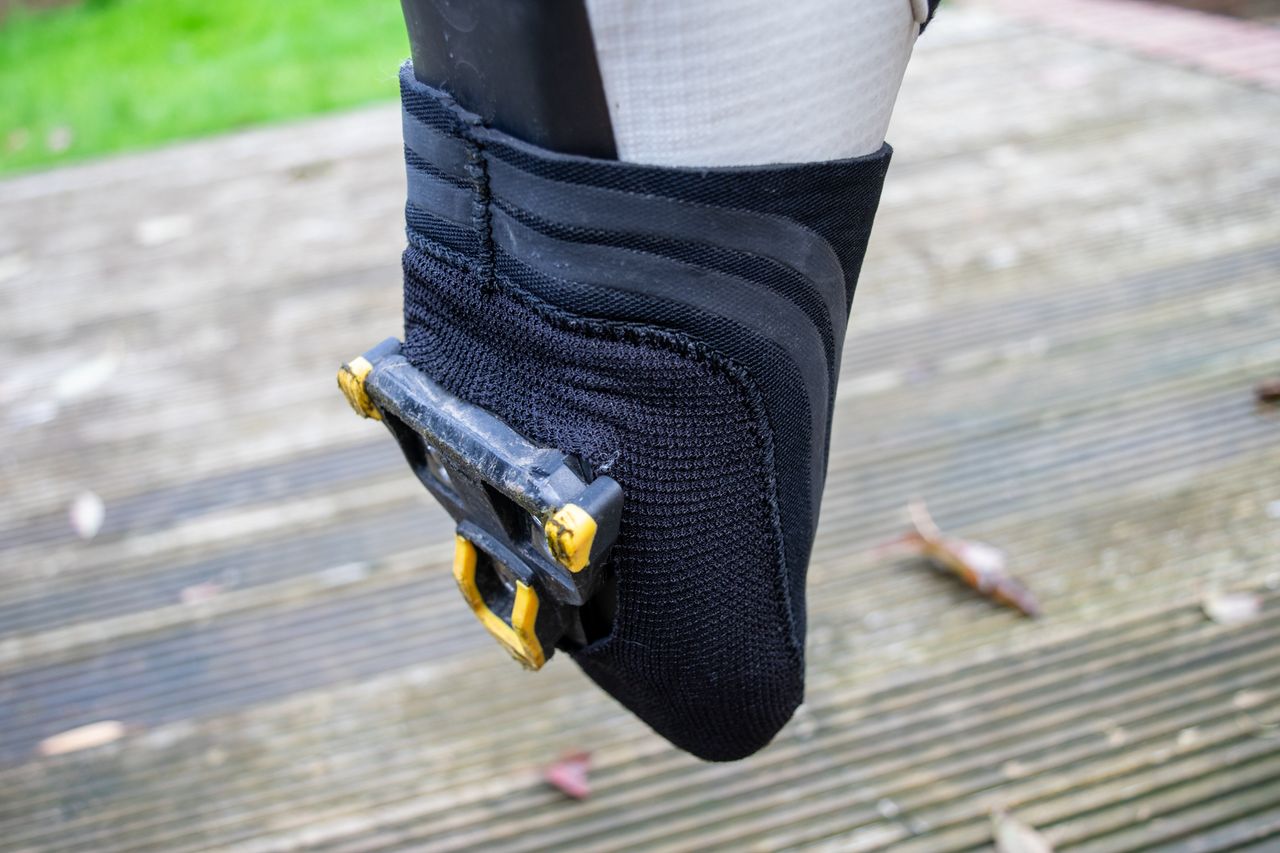 A cyclist wearing Spatz Pro Toez toe covers on wooden decking
