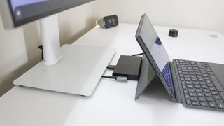 A laptop docking station between a monitor and a laptop