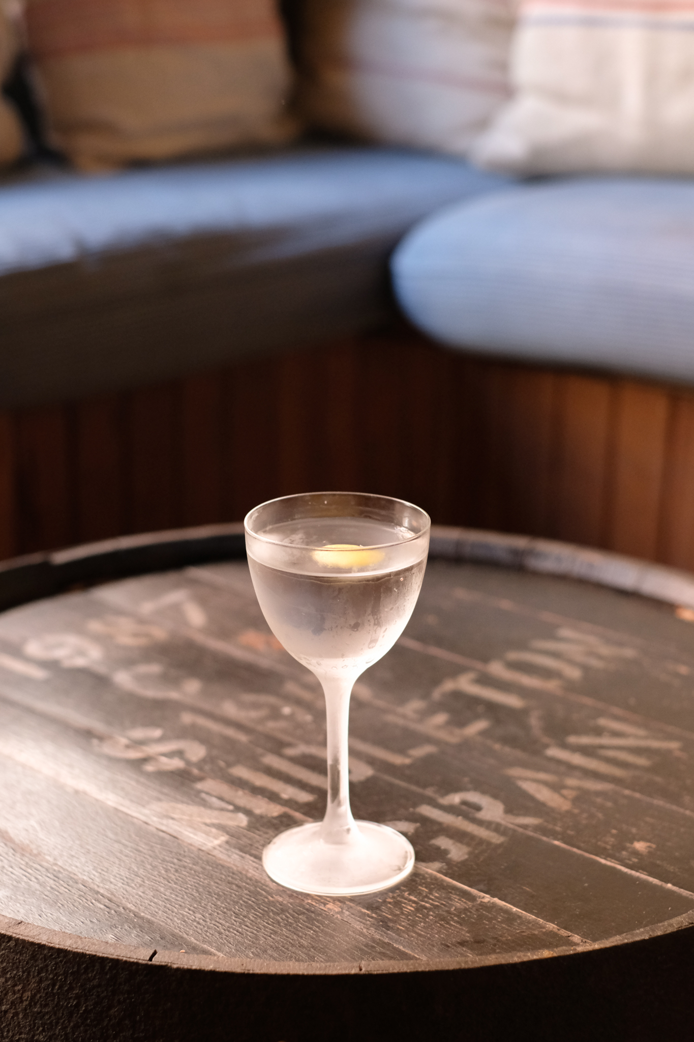 an image of a martini on a barrel style table in a cold glass