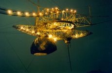 Arecibo Observatory's radio telescope's science platform illuminated at night.