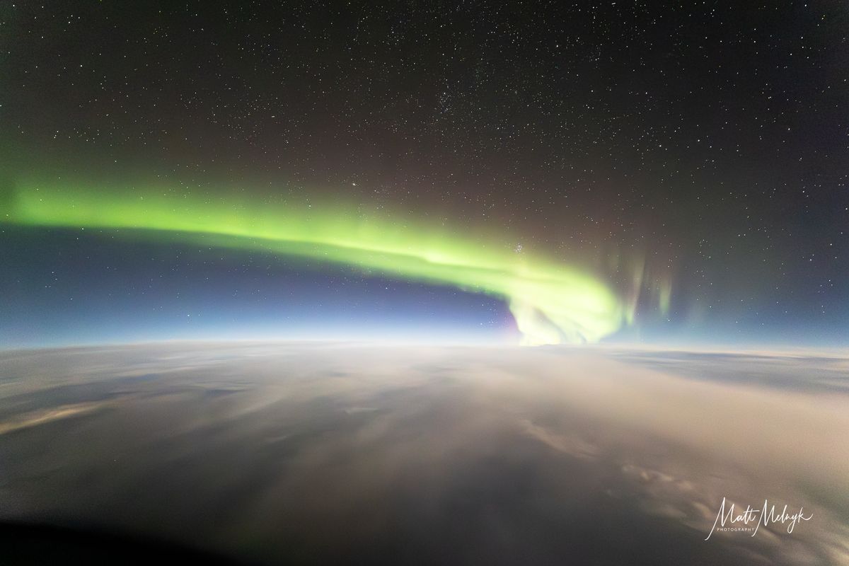 ribbons of green and purple light fill the sky in photos captured above the clouds from a dreamliner airplane.