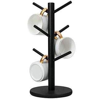 Matte black cup holder tree with six arms pointing upwards and a round base. There are three white cups hanging with gold handles in view