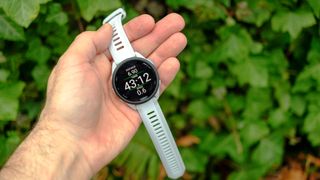 Garmin Forerunner 165 in a person's hand outside