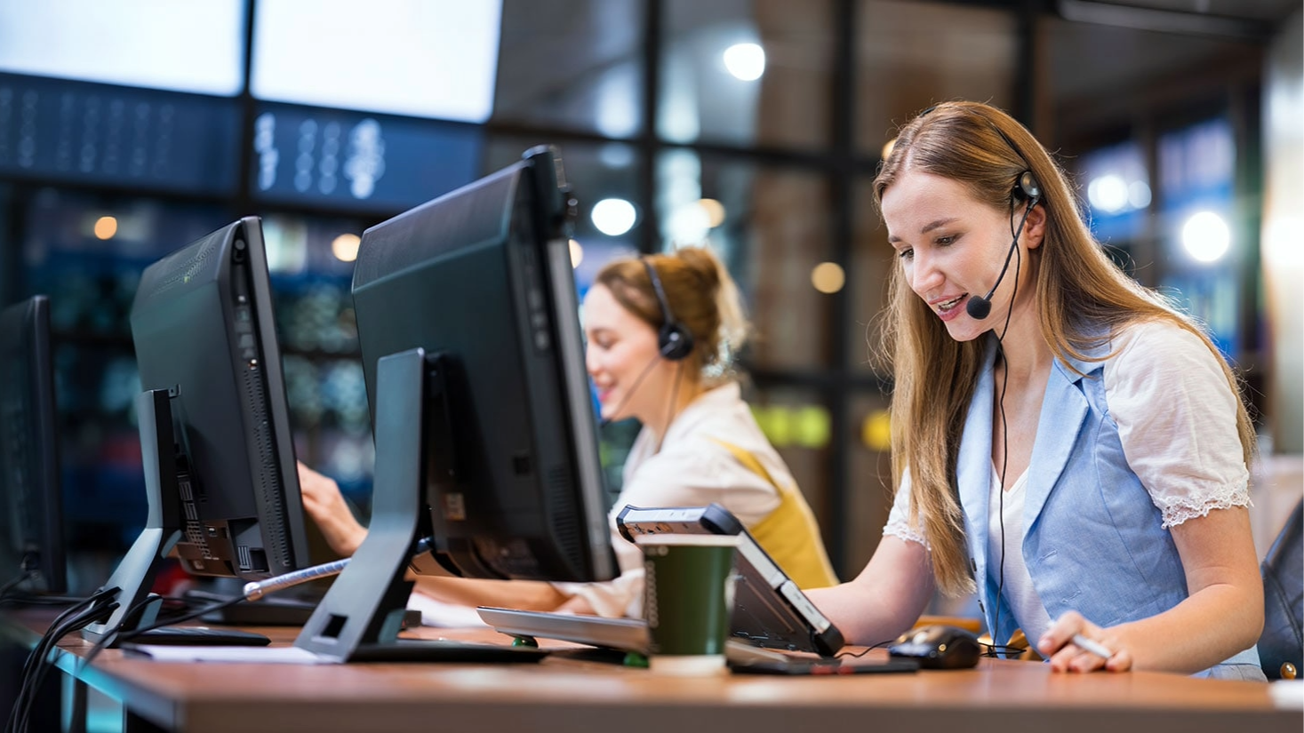 Two women in a call center in front of computers.