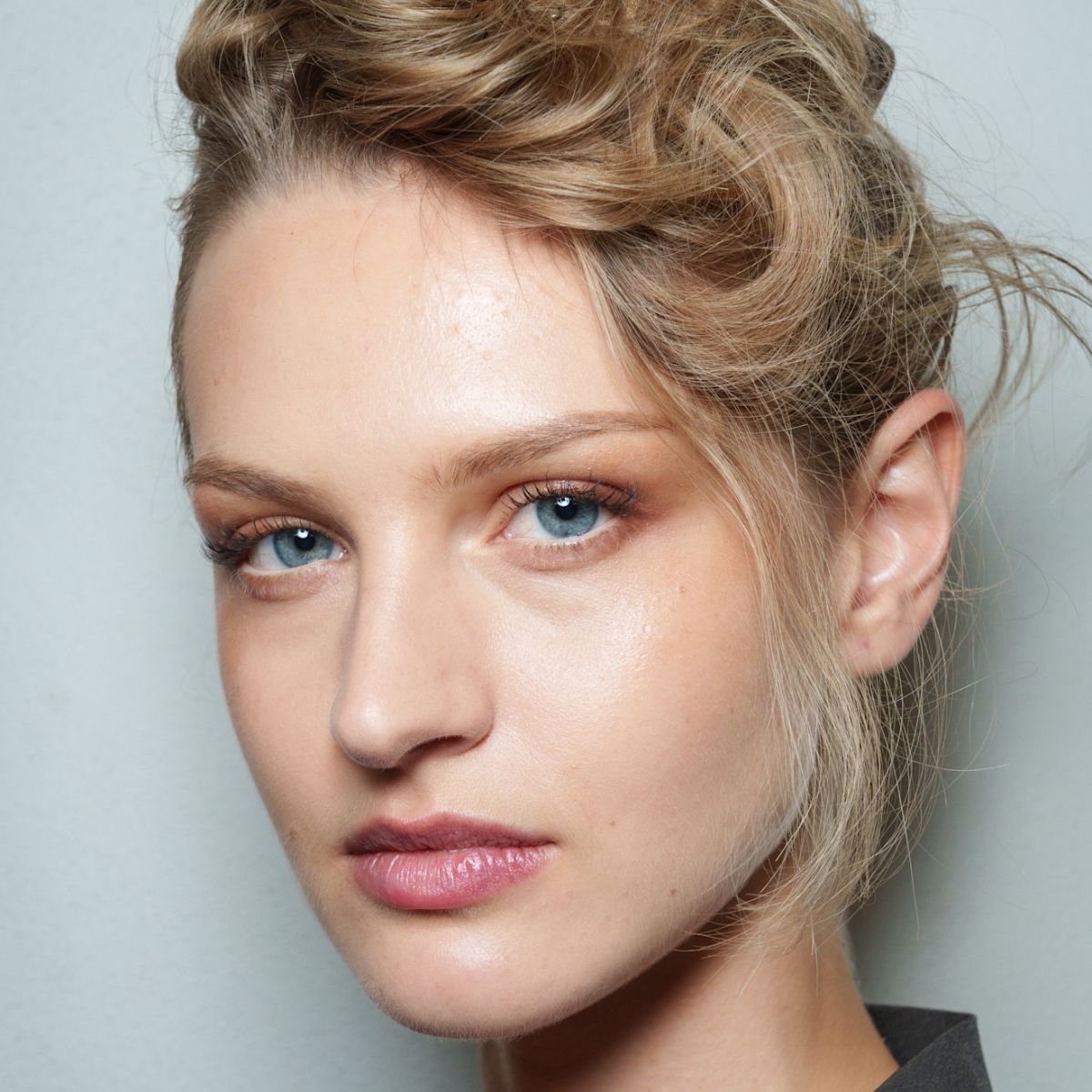 model backstage at fashion week with glowy skin