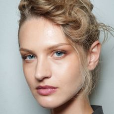 model backstage at fashion week with glowy skin