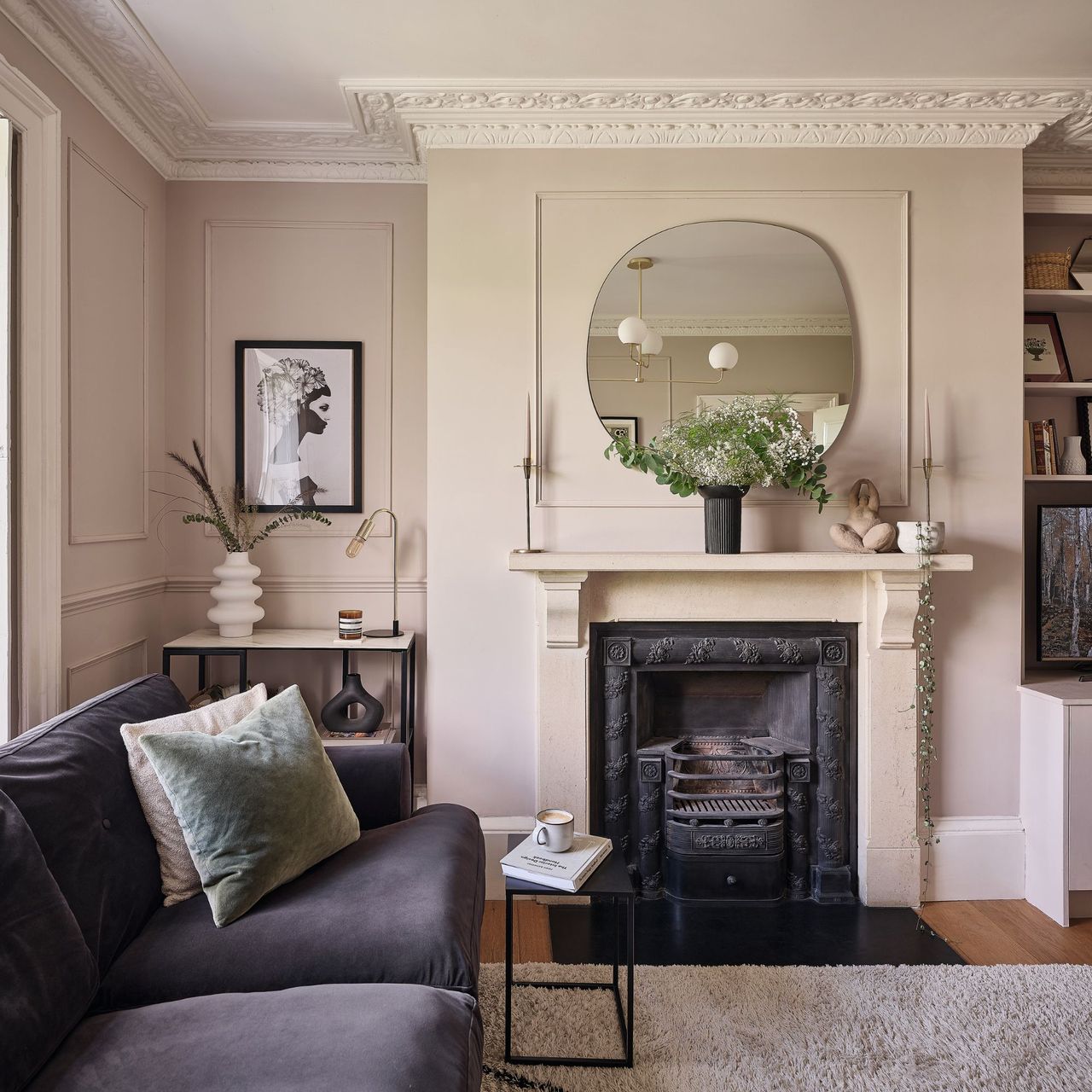 Light brown painted living room with an open fireplace, a grey sofa and cream rug on the floor