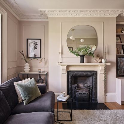 Light brown painted living room with an open fireplace, a grey sofa and cream rug on the floor