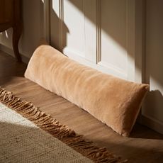 soft faux fur draught excluder resting on door