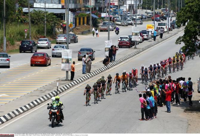 Fans cheer on the peloton as they go by