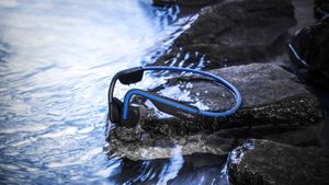 What are the best waterproof headphones for running: Pictured here, AfterShokz running headphones near a stream