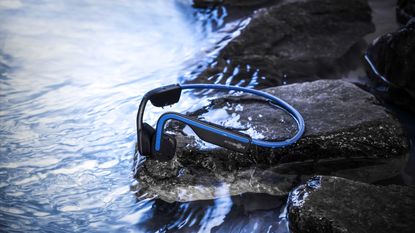 What are the best waterproof headphones for running: Pictured here, AfterShokz running headphones near a stream