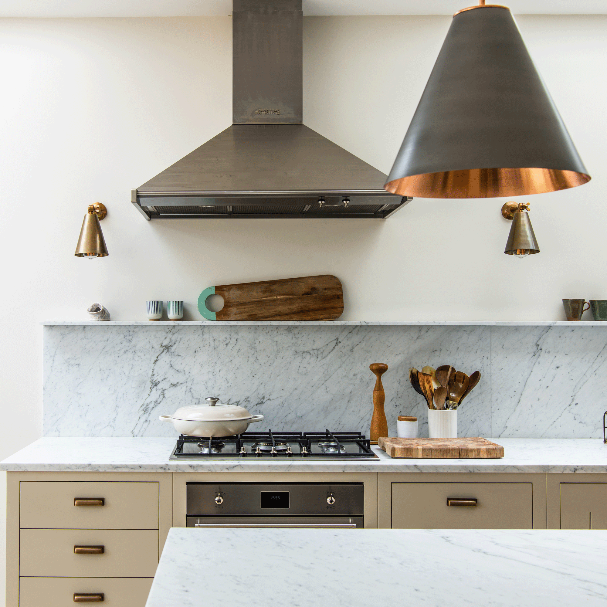 Kitchen with marble splashback and shelf alongside metallic lighting
