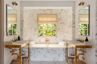 A marble bathroom with gold fixtures