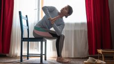 Woman practicing yoga on chair