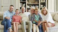 Portrait of happy three generation family sitting on sofa at home