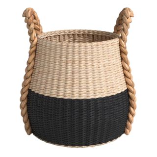 A black and beige two tone wicker basket with braided handles