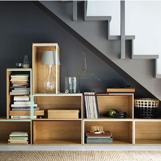 stairway with dark grey wall and cabinet with books