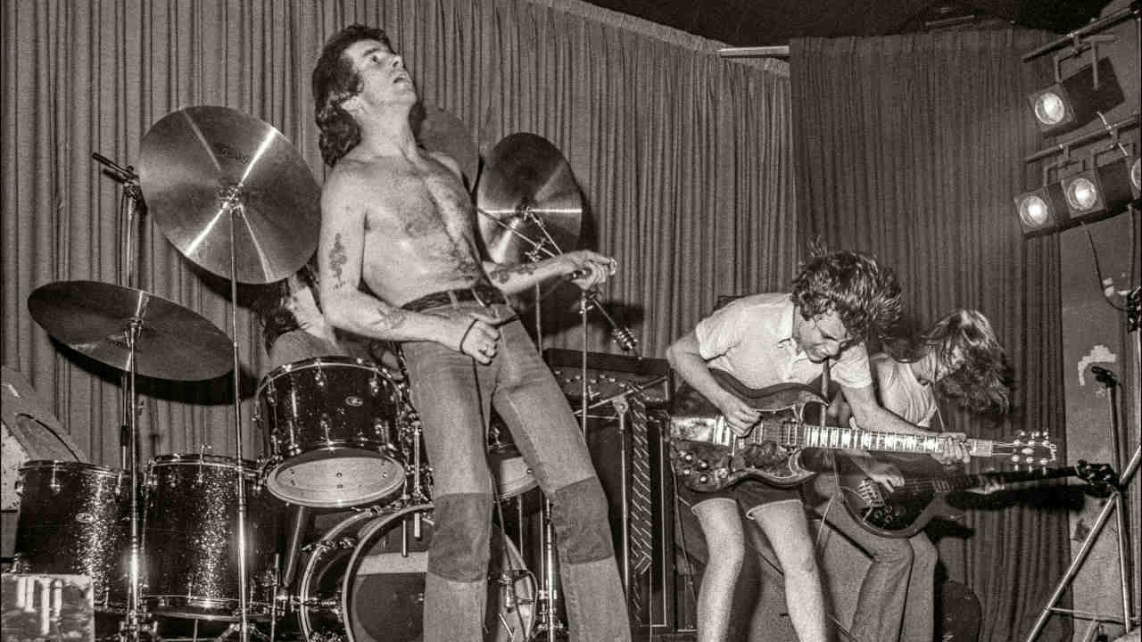 AC/DC performing onstage in 1976