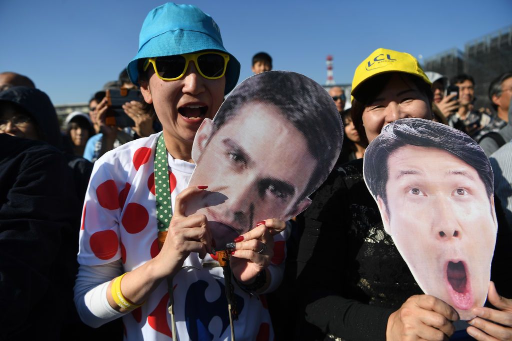 Fans hold cardboard cut-outs of Alberto Contador and Fumiyuki Beppu