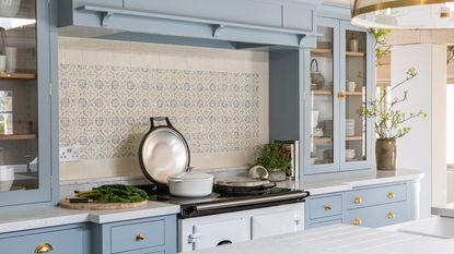 A blue painted kitchen with a white AGA stove. 