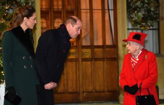 Queen Elizabeth II (R) talks with Prince William, Duke of Cambridge, (2L) and Catherine, Duchess of Cambridge, as they wait to thank local volunteers and key workers for the work they are doing during the coronavirus pandemic and over Christmas in the quadrangle of Windsor Castle on December 8, 2020