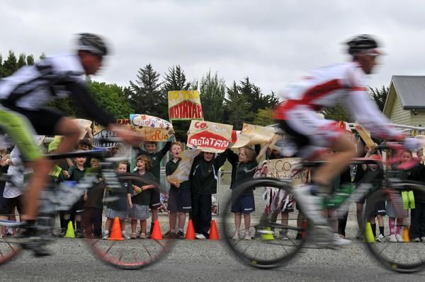 Riders are cheered on by enthusiastic school children.