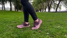 Woman wearing the HOKA Transport on grass