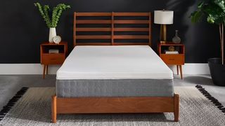 The Tempur-Pedic Tempur Topper Supreme mattress topper placed on a grey mattress that's sat on a wooden bed frame