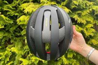 Female cyclist holding the Trek Velocis MIPS road bike helmet