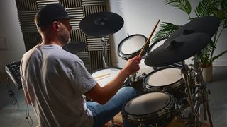 Man wearing black hat playing the Roland TD716 electronic drum set