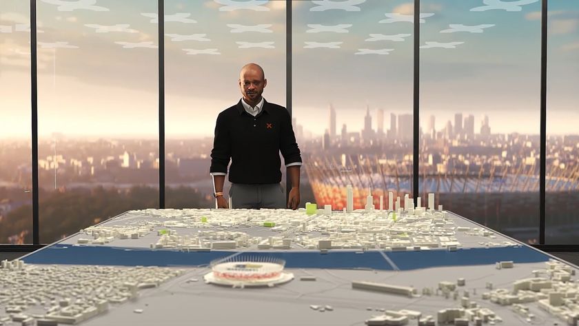 Copa City 25 - a man in a sweater stands behind a city plan diorama with a football stadium out the window