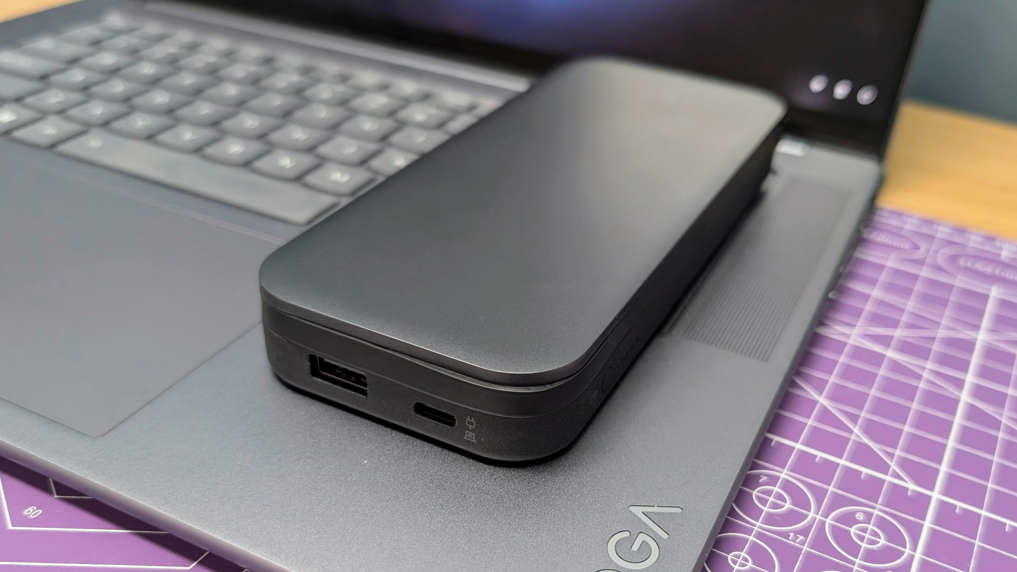 Lenovo Go USB-C laptop power bank sitting on a Yoga Slim 7i laptop to show the size