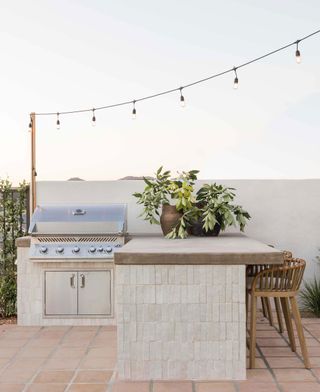 an outdoor kitchen design with a built-in grill