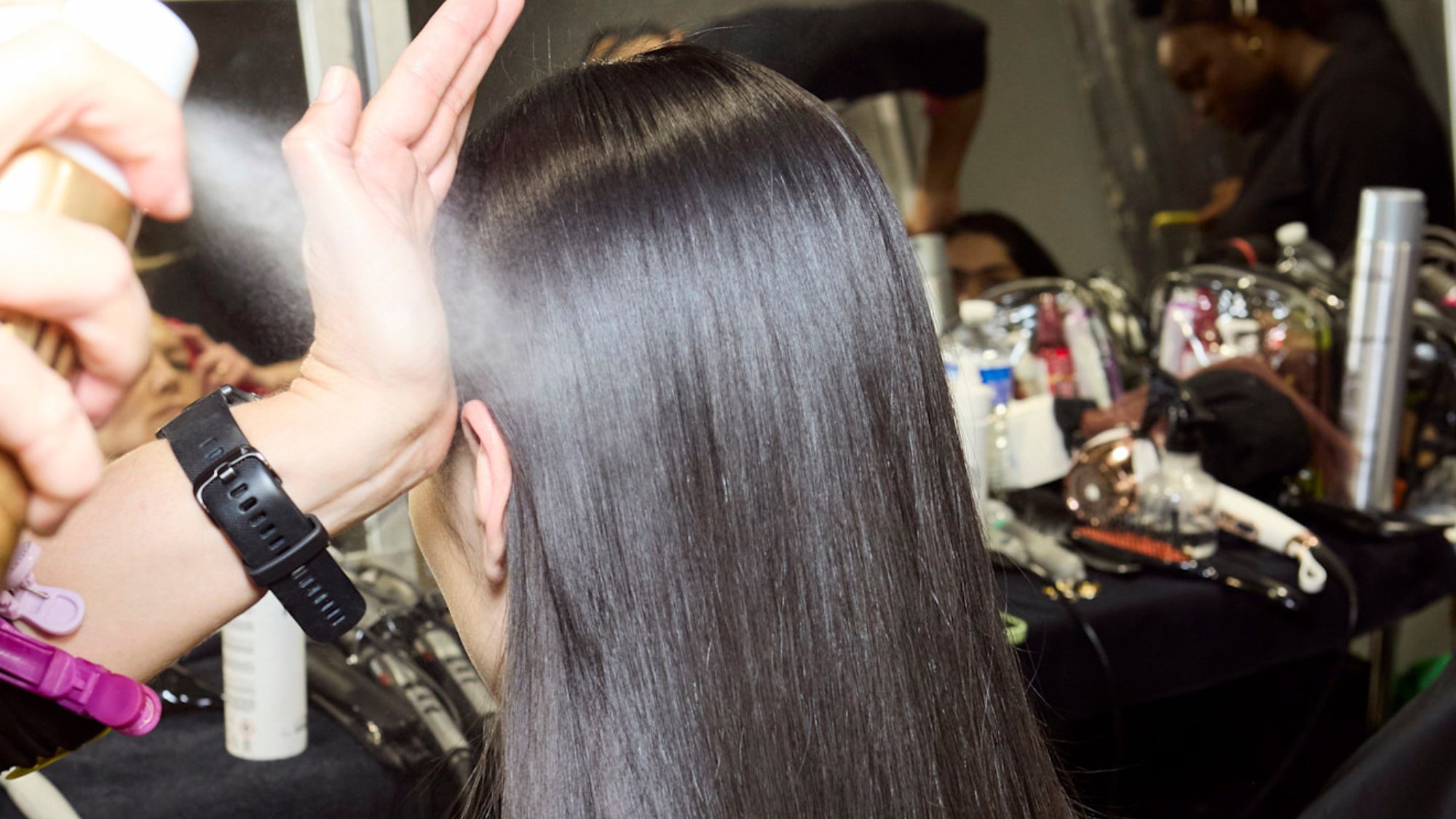 model backstage having hair done by a stylist
