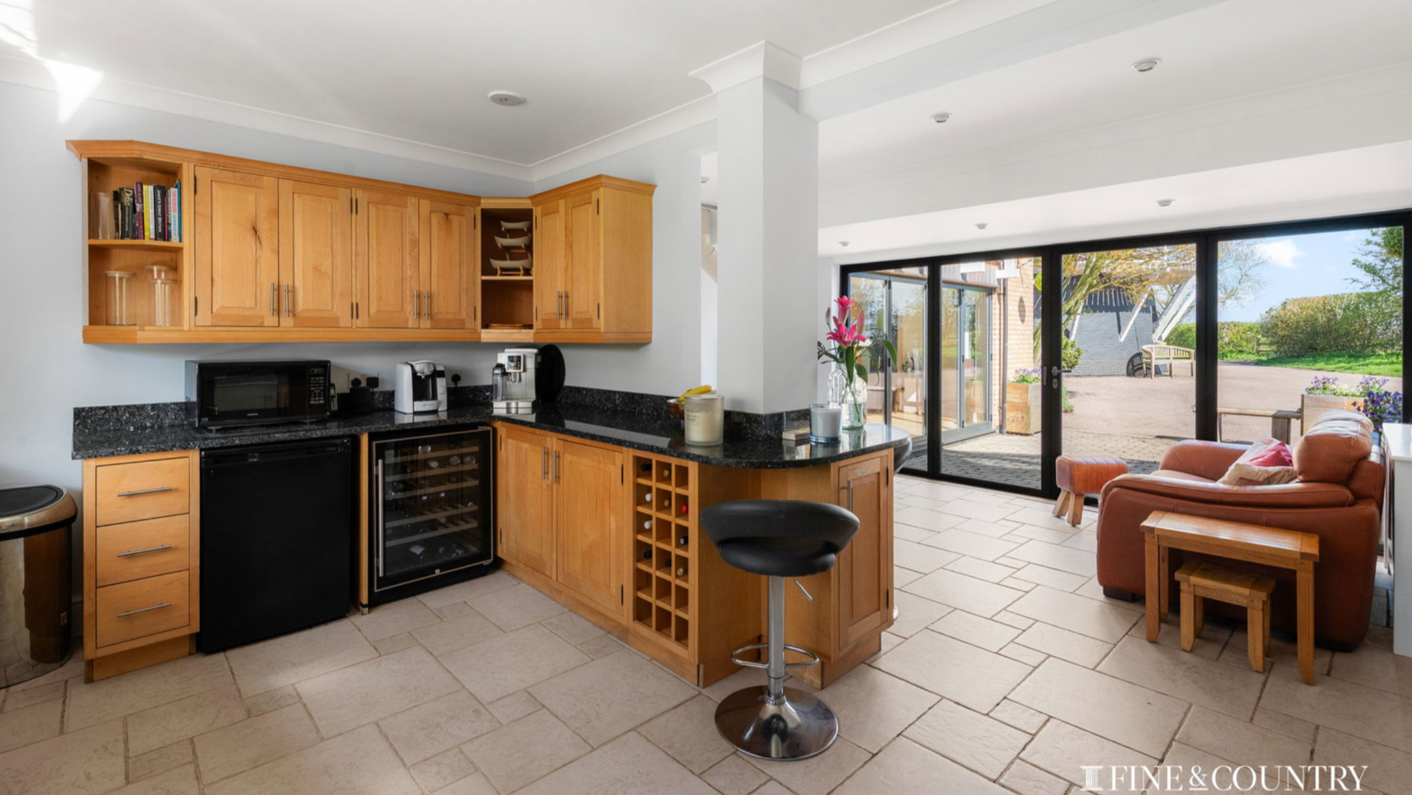 View of a kitchen with a stone floor and wooden cabinets