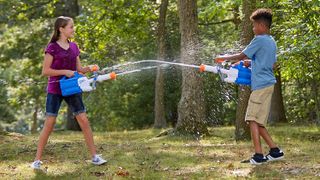 Two children spraying water at each other from water blasters