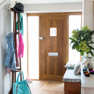 entrance hall with white wall wooden door hanger stand and wooden flooring
