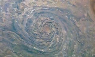 A cyclonic storm churns through Jupiter's northern hemisphere in this new view from NASA's Juno spacecraft. The swirling cloud formation looks a lot like a hurricane on Earth, with fluffy clouds sticking out from the storm's spiral arms. Juno captured this view with its JunoCam imager on Feb. 12, when it was about 5,000 miles (8,000 kilometers) above Jupiter's cloud tops.