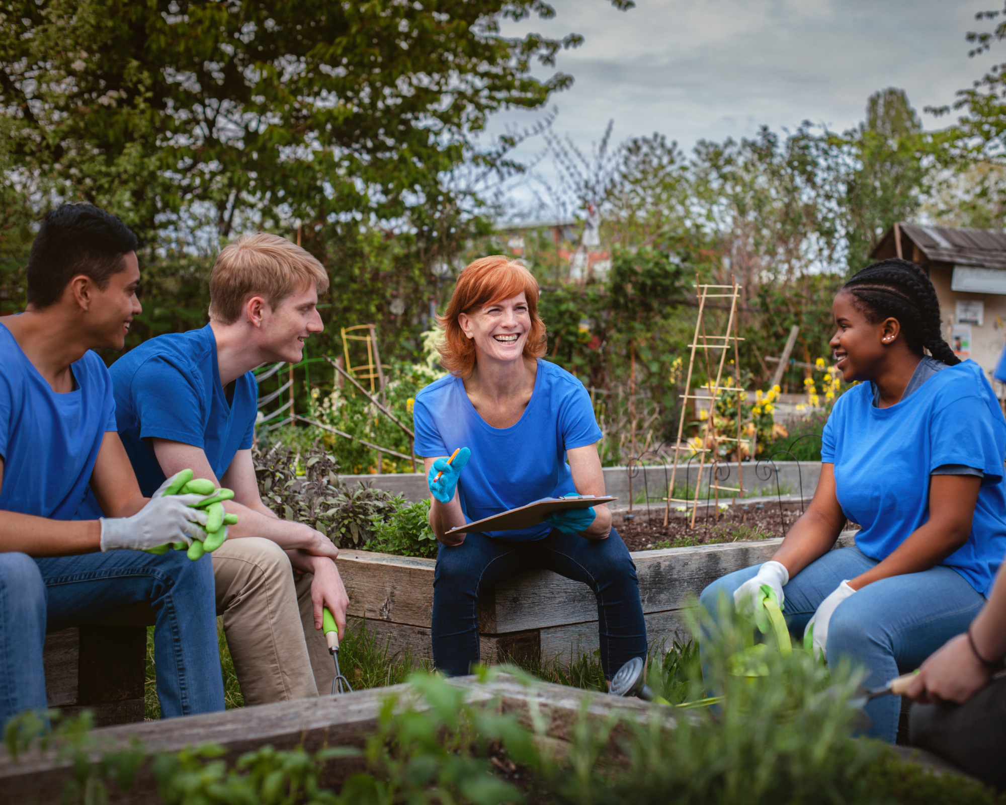 woman teaching young gardeners in a community garden plot