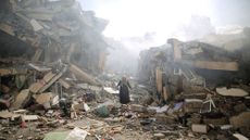 A person stands near destroyed buildings in Gaza