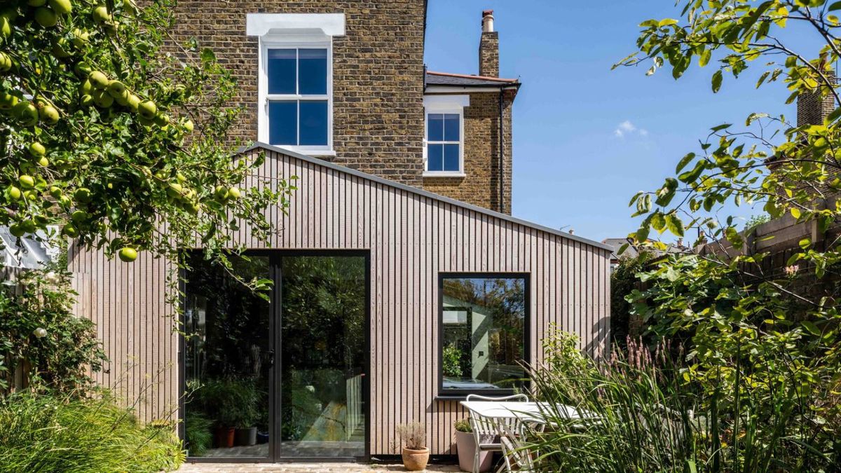 exterior shot of single storey wooden clad house extension on brick house