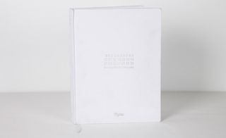 The white cotton embroidered front cover, emulating Margiela's stark labeling