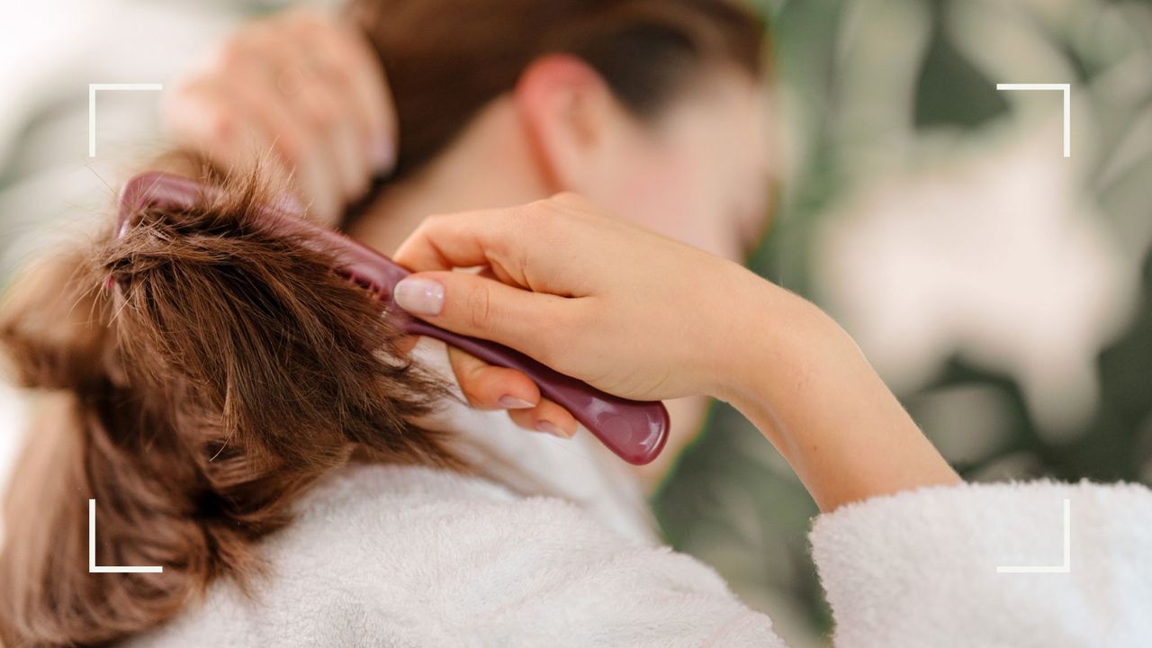 Woman brushing long hair with comb, demonstrating what causes thinning hair in women